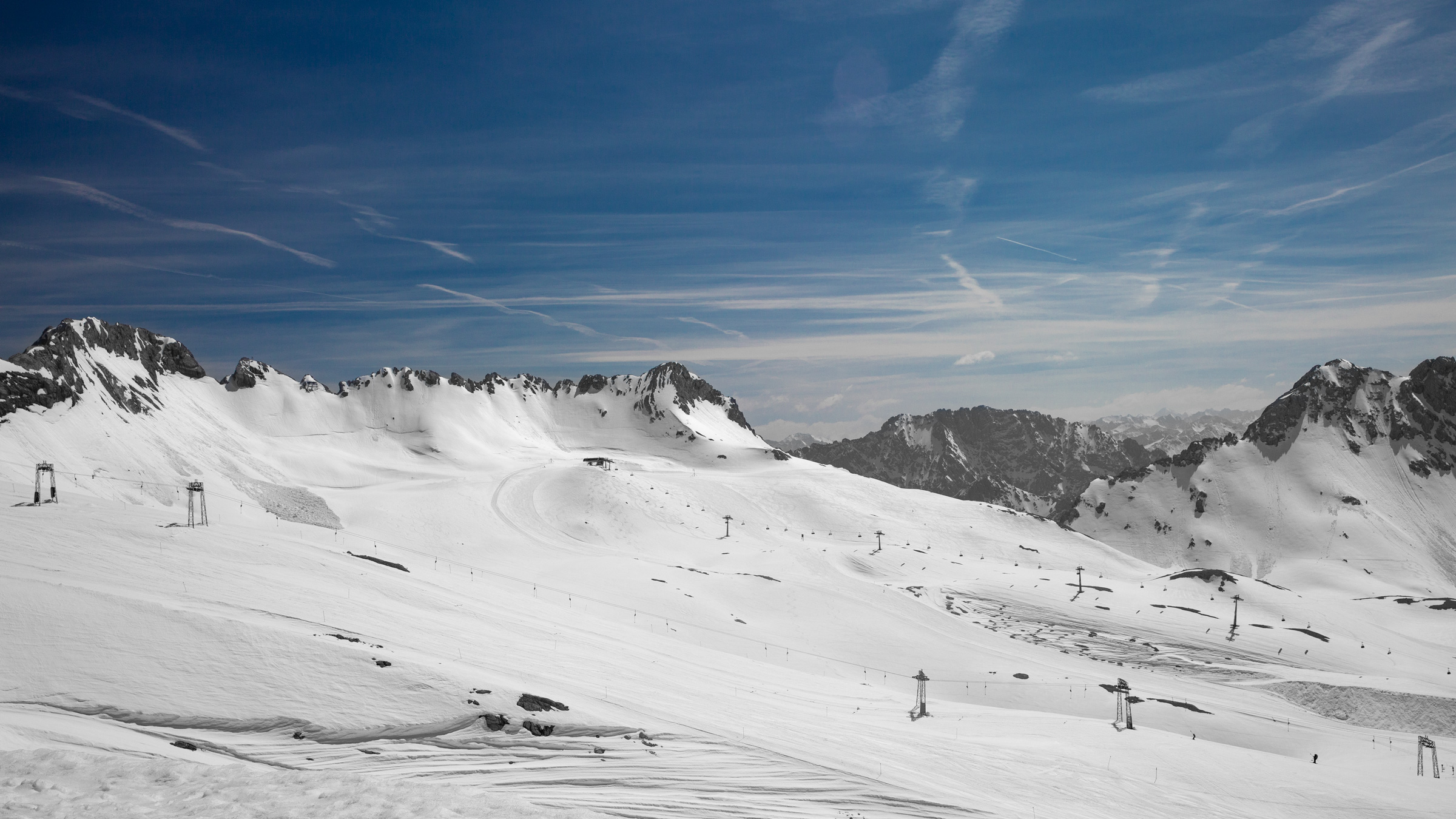 Alpenlandschaft mit schneebedeckten Bergen, Skiliften und blauem Himmel. Alps landscape with snowy mountains, skilifts and blue sky.