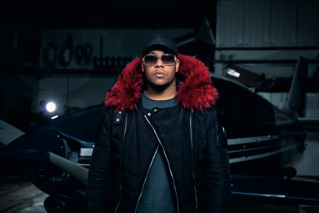 Covermotiv des Deutschrappers NOIR zu seiner Single "Horspist". Noir steht in seiner Horspist-Jacke in einem Flugzeug-Hangar. Cover motiv of German rapper NOIRs single "Horspist". NOIR stands in a hangar wearing his Horspist jacket.