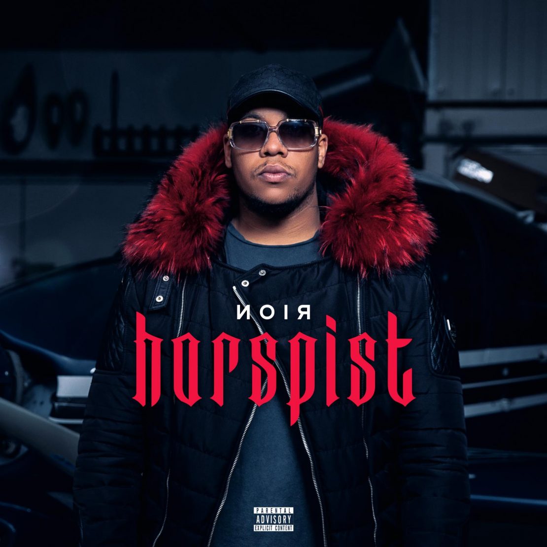 Cover des Deutschrappers NOIR zu seiner Single "Horspist". Noir steht in seiner Horspist-Jacke in einem Flugzeug-Hangar. Cover of German rapper NOIRs single "Horspist". NOIR stands in a hangar wearing his Horspist jacket.