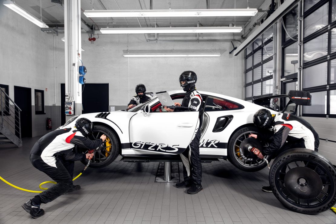 Mechanics working on a Manthey GT2RS MR in a workshop for the Porsche Service Campaign.